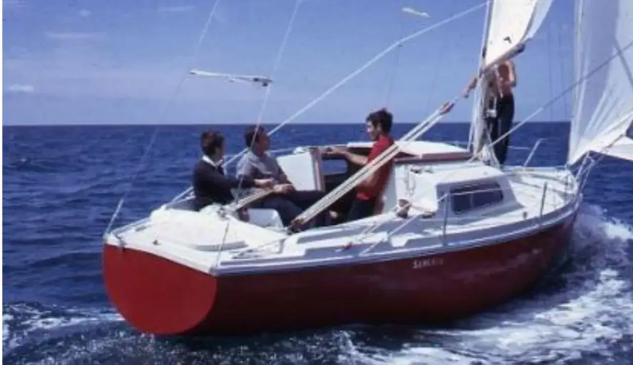 Voilier Sangria naviguant, une fiche technique de ce bateau classique. Quatre personnes à bord profitent de la mer bleue.