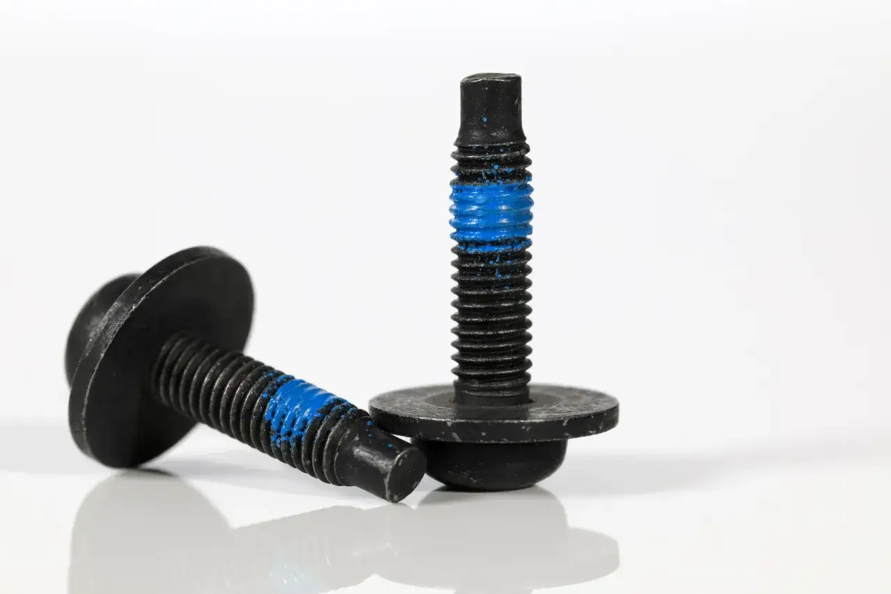Deux vis noires avec un filetage bleu, une astuce pour savoir comment bloquer une vis qui se d&eacute;visse.