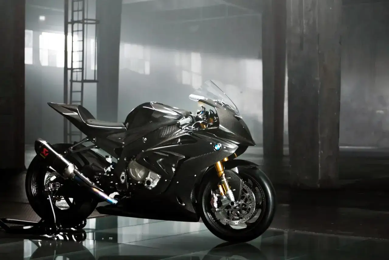 La BMW HP4 Race, una obra maestra de fibra de carbono, descansa en un almac&eacute;n industrial, lista para la pista.