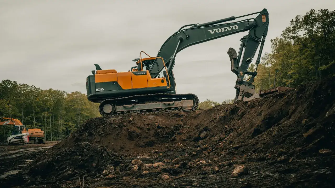 Koparka Volvo EC220DL na placu budowy, gotowa do pracy. To idealny sprzęt do odpowiedzi na pytania na egzamin koparki kl 1.