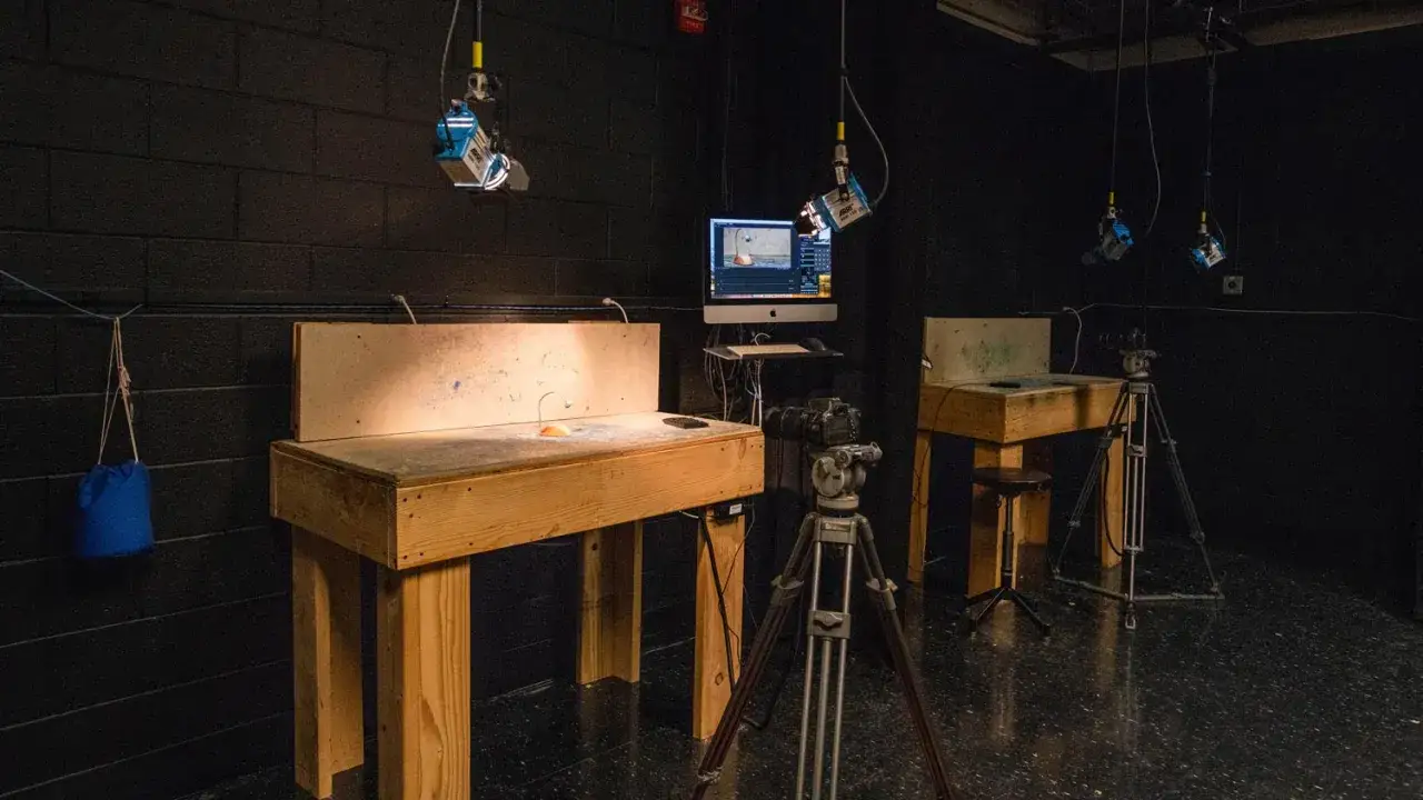 Studio do tworzenia animacji poklatkowej z oświetleniem, kamerą na statywie i monitorem.