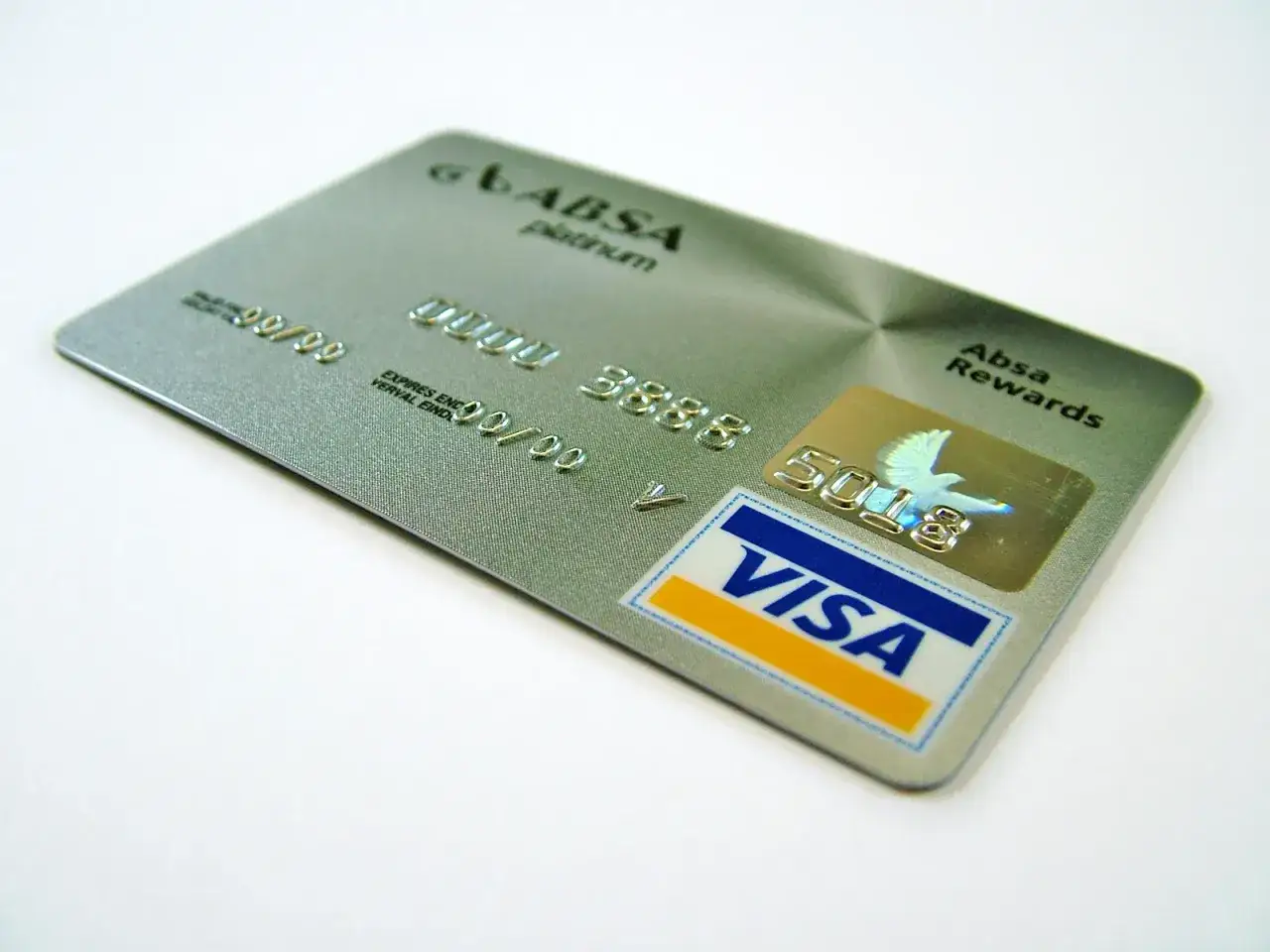 Srebrna karta płatnicza z hologramem ptaka i logo Visa. Ta złota karta to symbol prestiżu i możliwości.