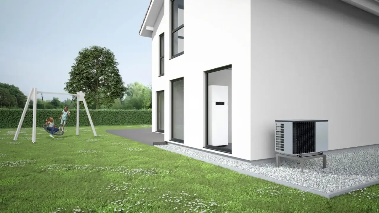 Casa moderna con jardín y columpio. Una bomba de calor frío exterior y una unidad interior blanca garantizan confort todo el año.