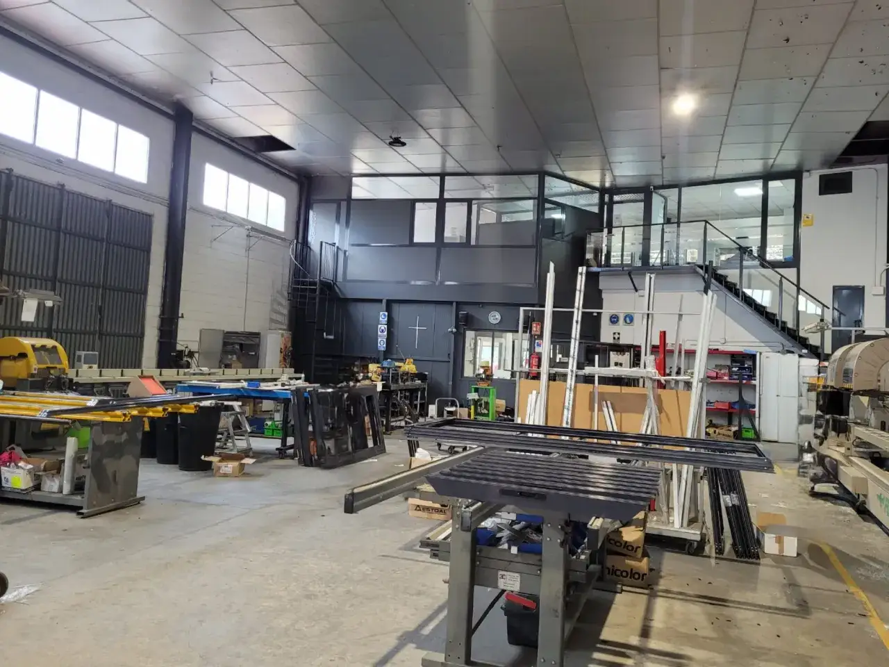 Taller de fabricaci&oacute;n de ventanas de aluminio con maquinaria y perfiles listos para el ensamblaje.