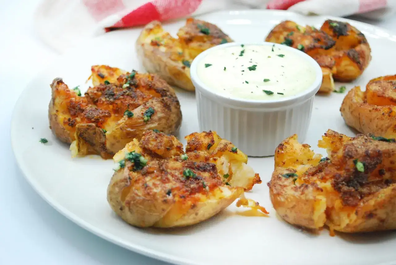 Patatas asadas crujientes y doradas, servidas con una cremosa salsa de ajo y hierbas. &iexcl;Un aperitivo irresistible!