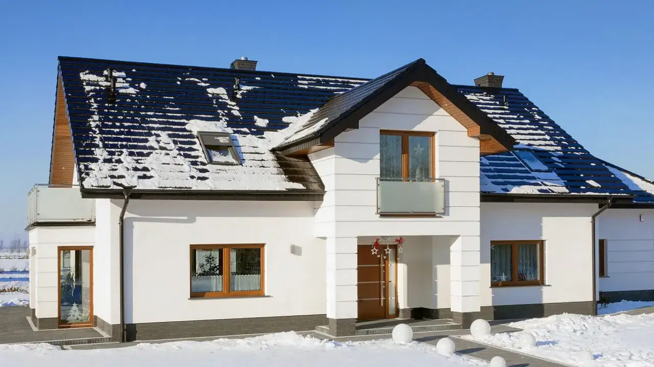 Nowy dom z czarną dachówką ceramiczną, która świetnie wygląda nawet ze śniegiem. Sprawdź, jaka jest dachówka ceramiczna cena za m2!