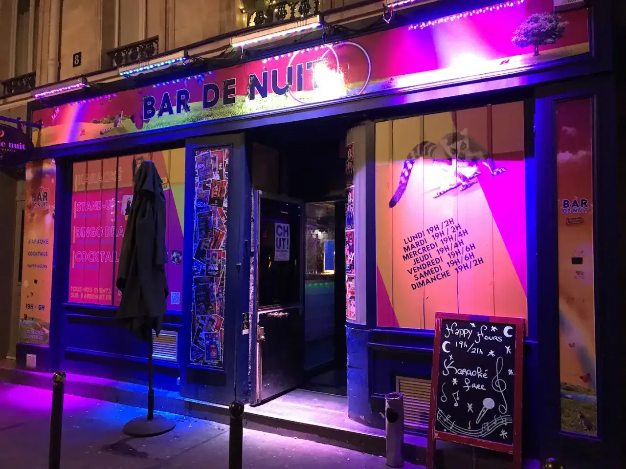 Bar gay paris illuminé de néons roses et bleus, proposant karaoké, stand-up et cocktails. Ouvert tard.