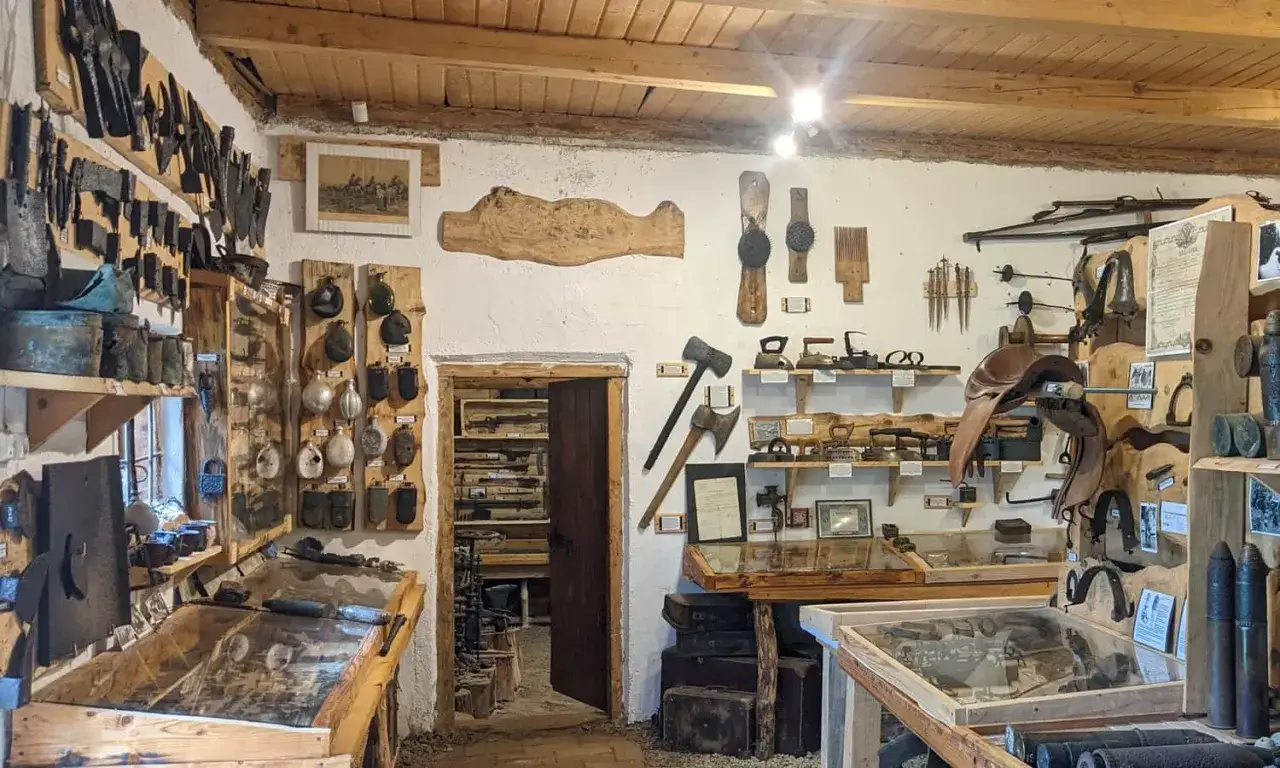 Wnętrze muzeum historii Bieszczad w Czarnej Górnej. Eksponaty to narzędzia, broń, siodło, żelazka i inne przedmioty codziennego użytku.