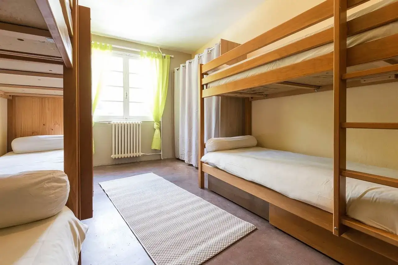 Chambre avec lits superposés en bois. Une fille et un garçon pourraient partager cette chambre, avec des lits pour chacun.