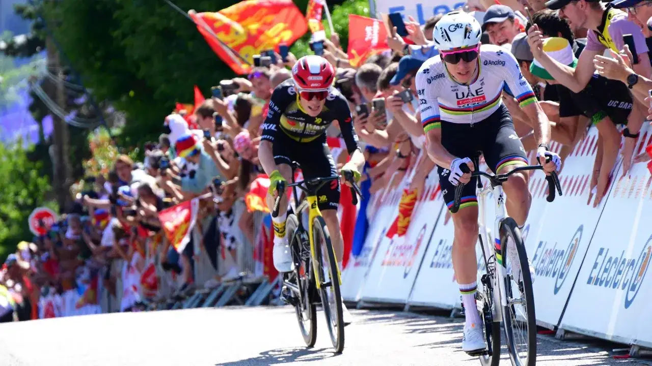 Zwei Radfahrer k&auml;mpfen sich bergauf, die Menge jubelt. Vingegaard im gelben Trikot, sein Gegner im Weltmeister-Trikot. Tour de France Spannung pur.