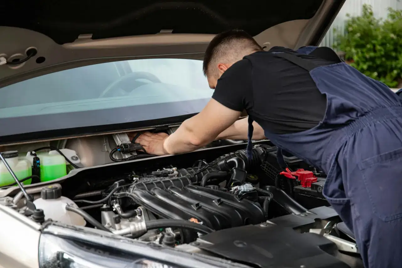 Mechanik sprawdza silnik, szukając objawów uszkodzonych wtrysków benzyny.