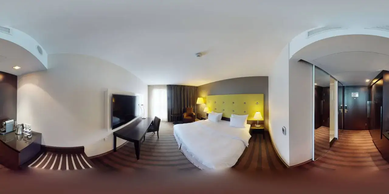 Przytulny pokój hotelowy w Radisson Blu Sobieski Hotel Warsaw: łóżko, biurko, TV i kącik kawowy.