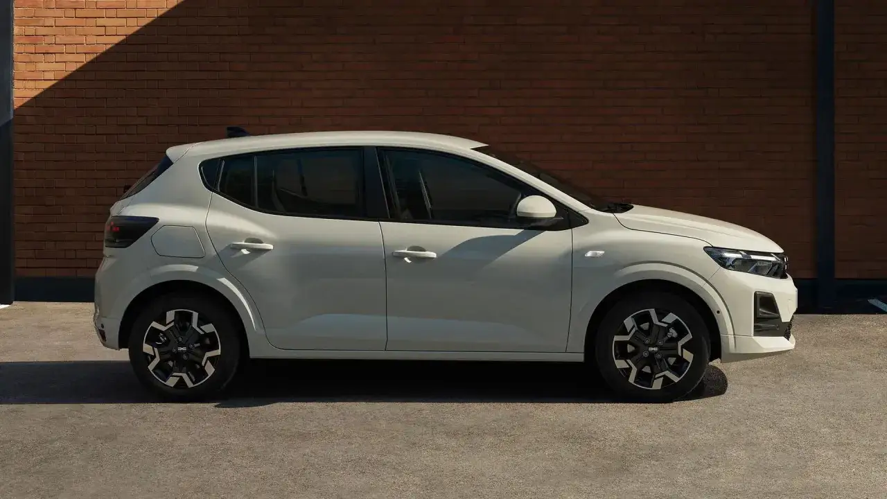 Vit Dacia Sandero st&aring;r parkerad mot en tegelv&auml;gg. &Auml;r Dacia bra eller d&aring;lig? Denna modell ser lovande ut!