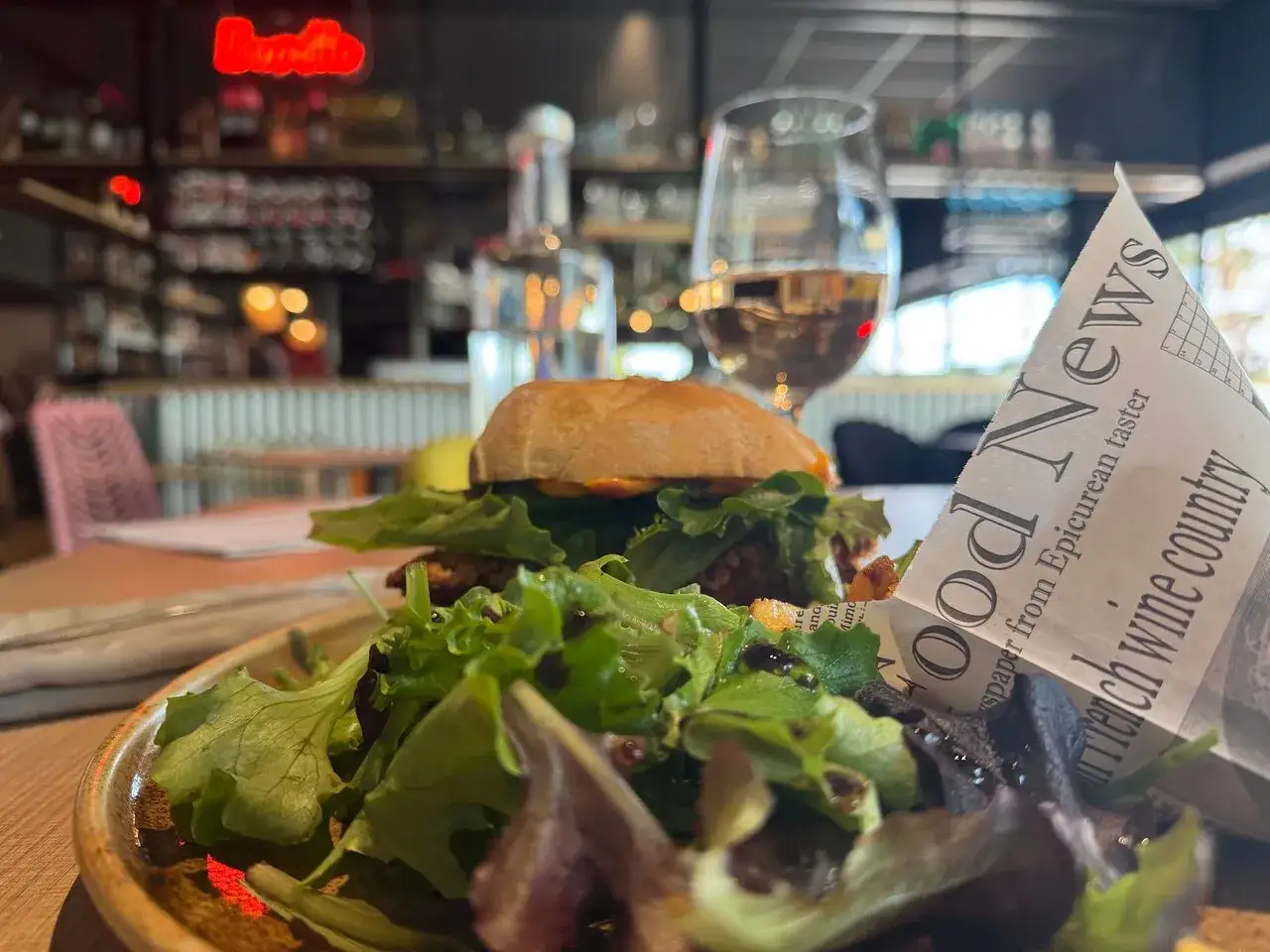 Un délicieux burger et sa salade fraîche au restaurant La Javette, accompagné d'un verre de vin blanc.