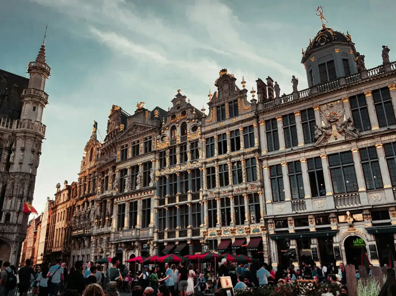 Grand Place, Brussels, with ornate buildings and a crowd enjoying the atmosphere. Perfect for exploring on Brussels bike tours.