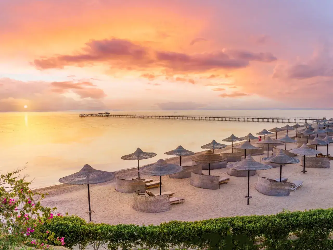 Piękny wschód słońca nad morzem, plaża z parasolami i leżakami. Idealne miejsce na wakacje last minute all inclusive najtaniej.