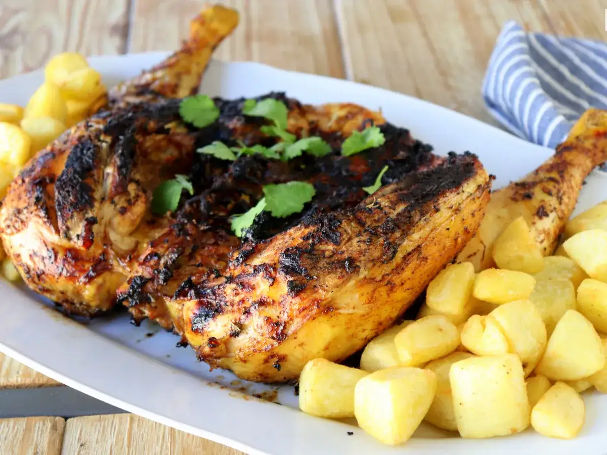 Pollo a la brasa jugoso y dorado, con papas fritas crujientes y perejil fresco. ¡Un festín para los sentidos!