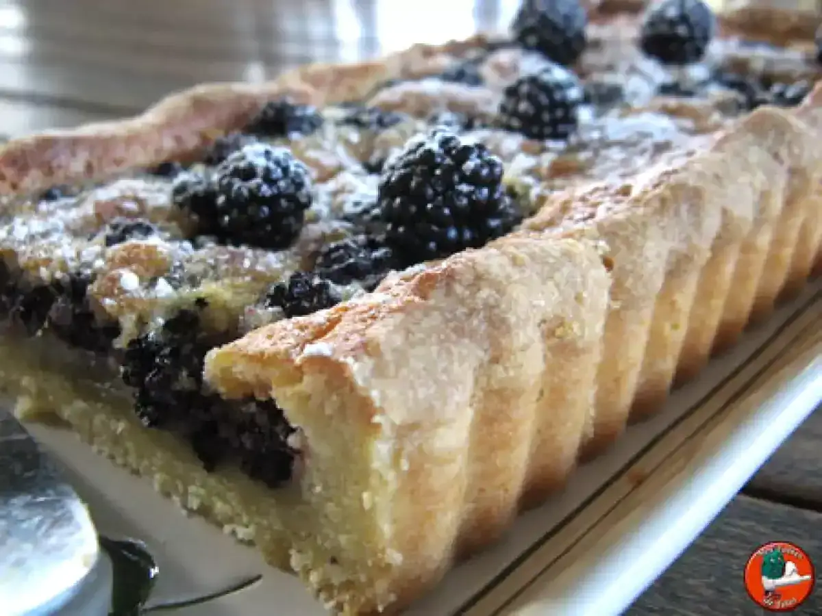 Tarte aux mûres fraîchement sortie du four, saupoudrée de sucre glace. Un délice gourmand.