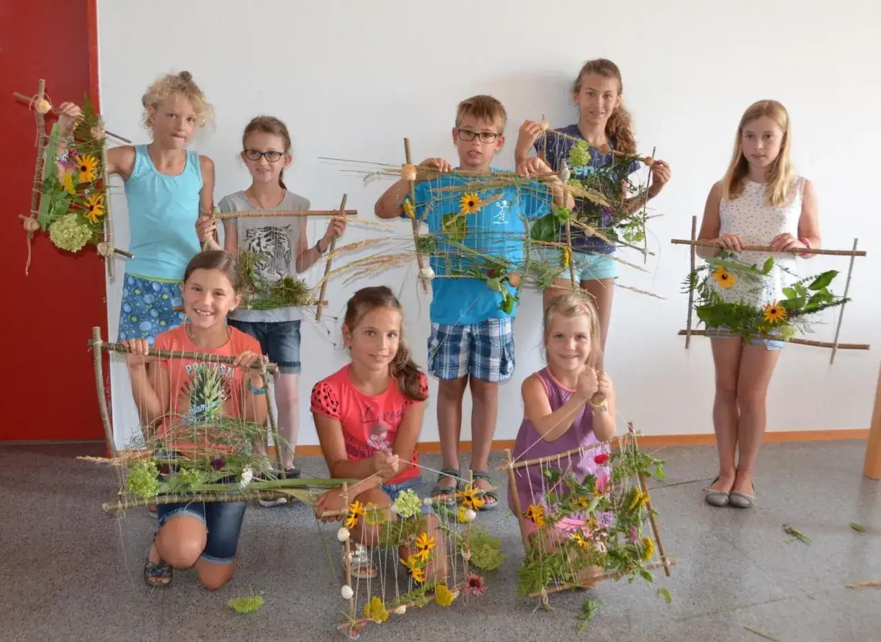 Kinder pr&auml;sentieren ihre selbstgemachten Blumenbilder, tolle ferienprogramm grundschule ideen.