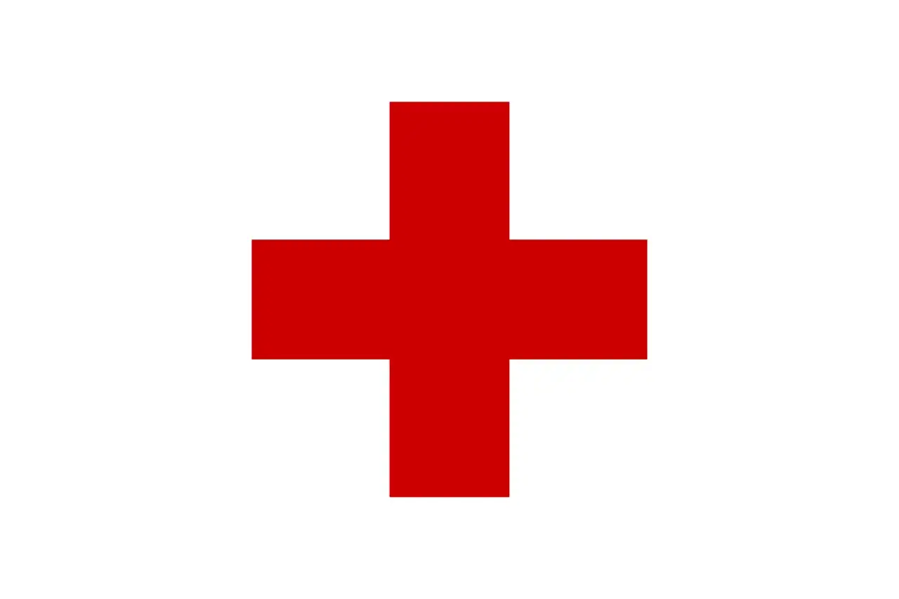 Flaga z czerwonym krzyżem na białym tle. Symbol pomocy i nadziei.