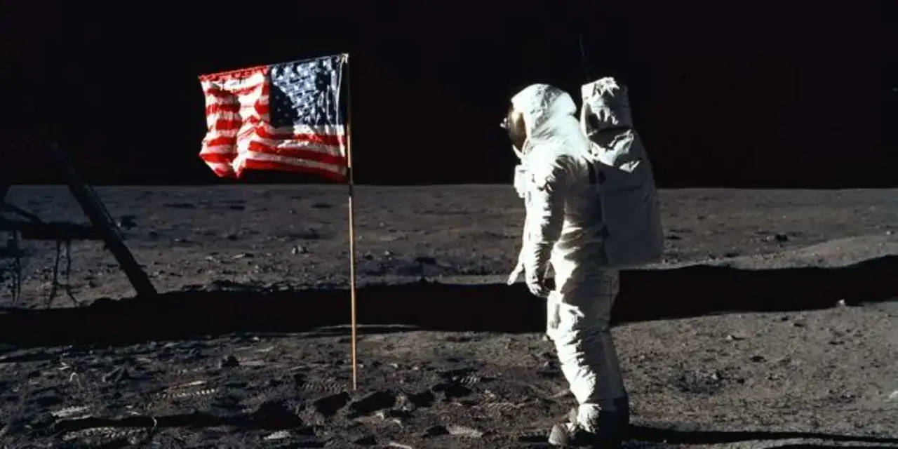 20 juillet 1969. Un astronaute se tient pr&egrave;s du drapeau am&eacute;ricain sur la Lune, un moment historique.