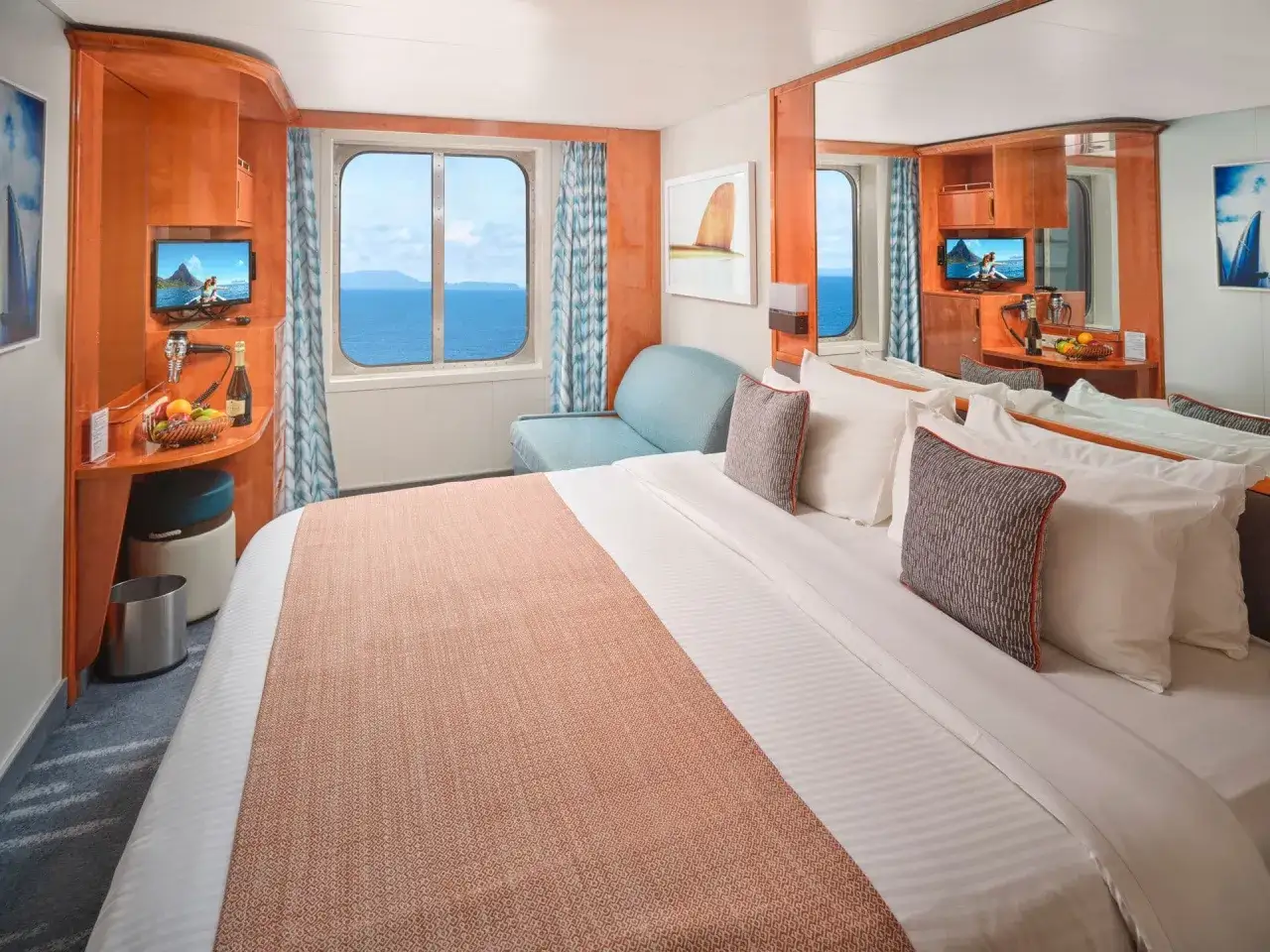 Accogliente cabina esterna crociera con vista mare, letto comodo, divanetto e TV.