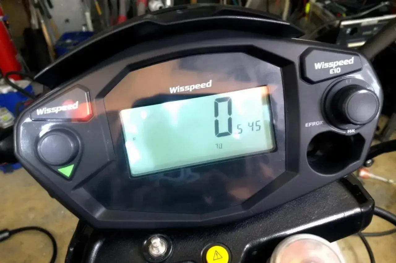 Tableau de bord d'une trottinette &eacute;lectrique Wispeed E10. L'&eacute;cran affiche 0 km/h, 5:45 et 70. Pr&ecirc;t pour r&eacute;initialiser trottinette &eacute;lectrique Wispeed.