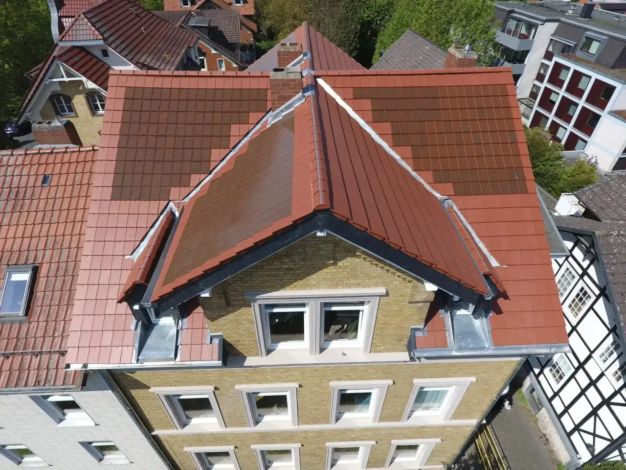 Dachfl&auml;chen mit neuen und alten Ziegeln, ein Zeichen f&uuml;r energetische Sanierung. Beratung f&uuml;r Ihr Zuhause.
