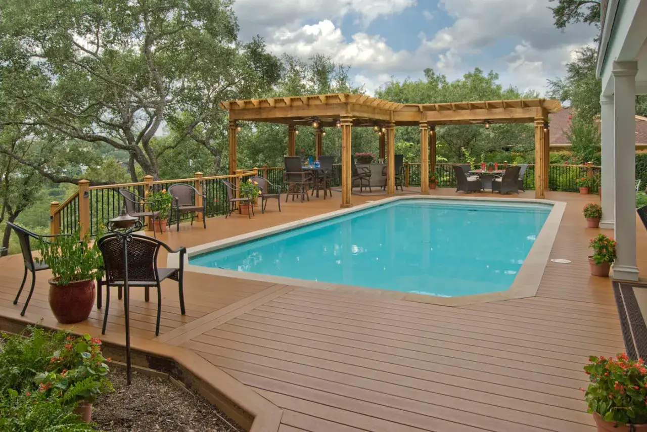Un magnifique jardin avec piscine, entouré d'une terrasse en bois et d'une pergola. Parfait pour se détendre.