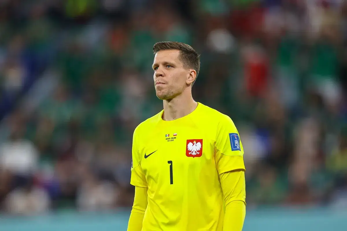 Wojciech Szczęsny, bramkarz Polski, w żółtej koszulce z numerem 1. Jego imponujący wzrost pozwala mu na skuteczną obronę bramki.