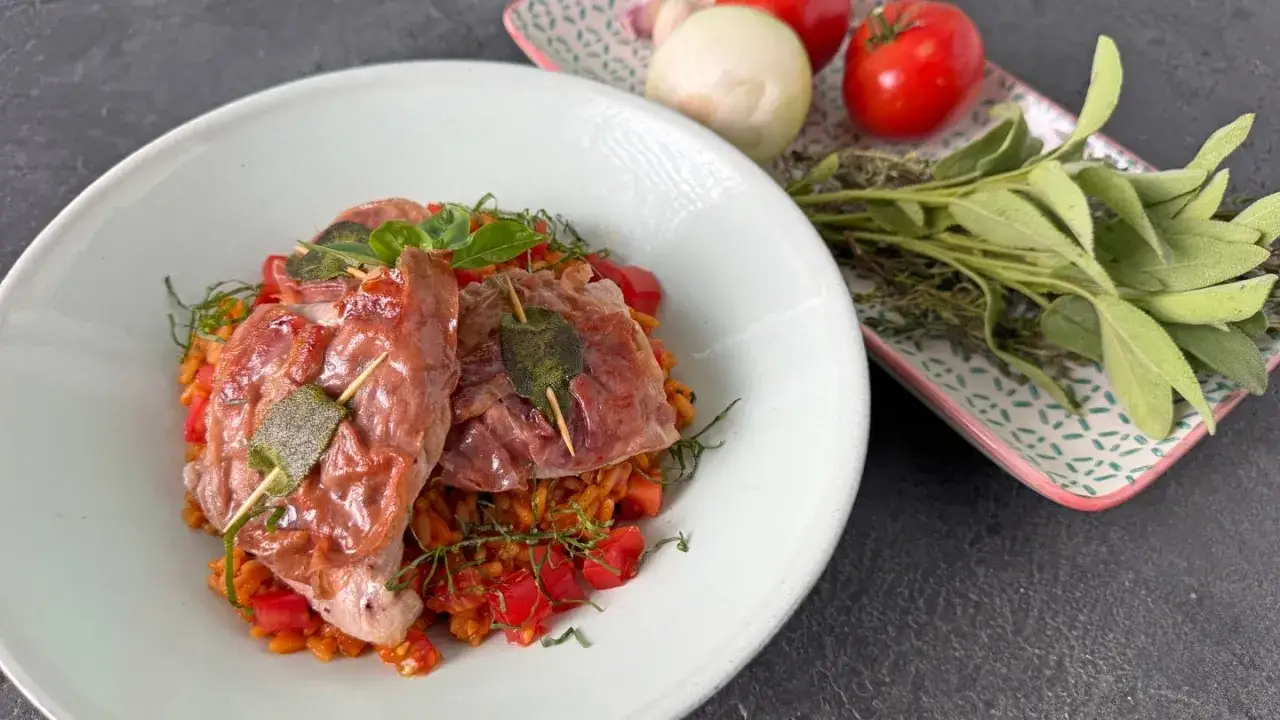 Saltimbocca alla Romana: zarte Kalbsschnitzel mit Salbei und Prosciutto auf einem Bett aus Orzotto mit Tomaten.