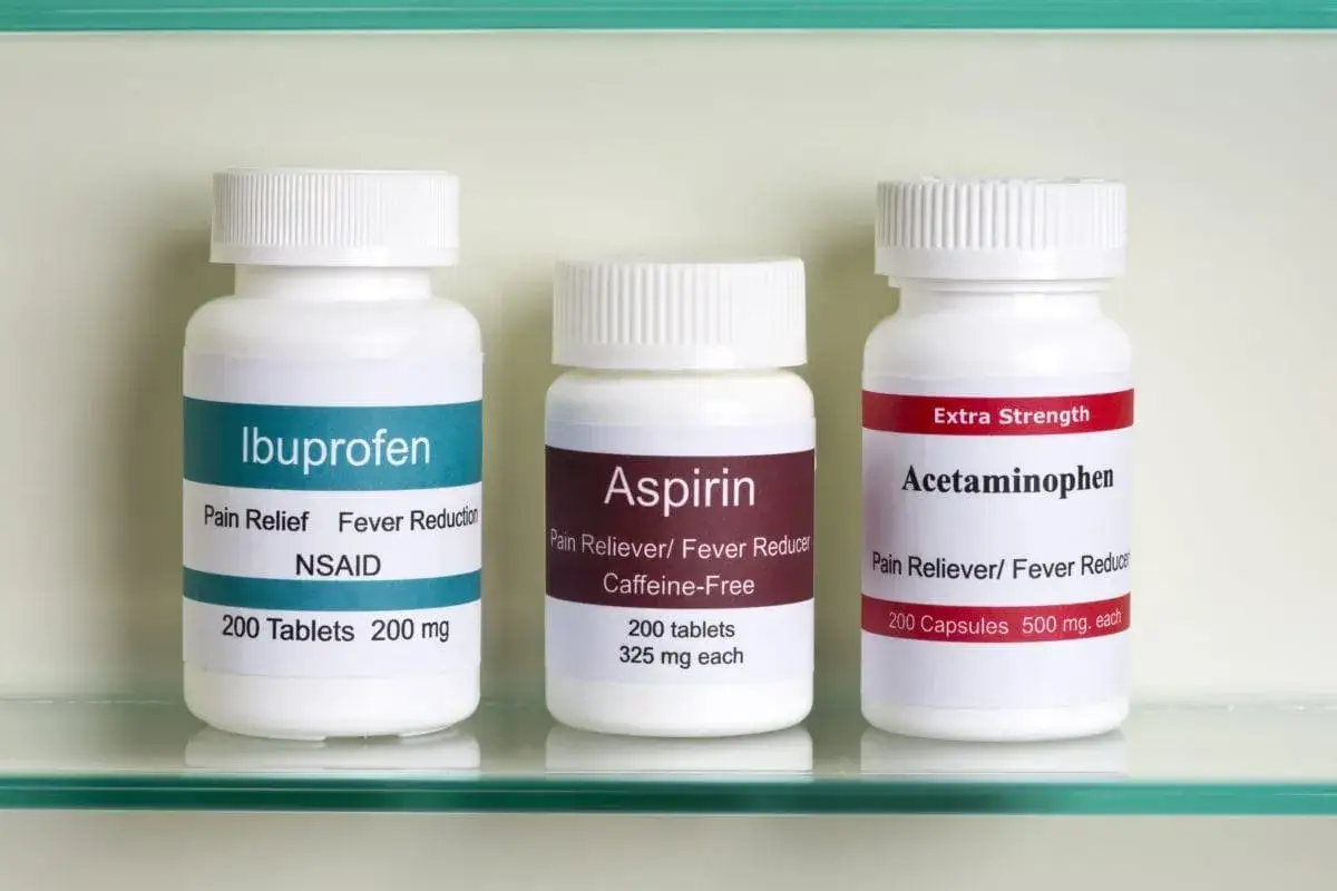 Trzy butelki leków: Ibuprofen, Aspiryna i Acetaminophen. To popularne tabletki na ból zęba i inne dolegliwości.