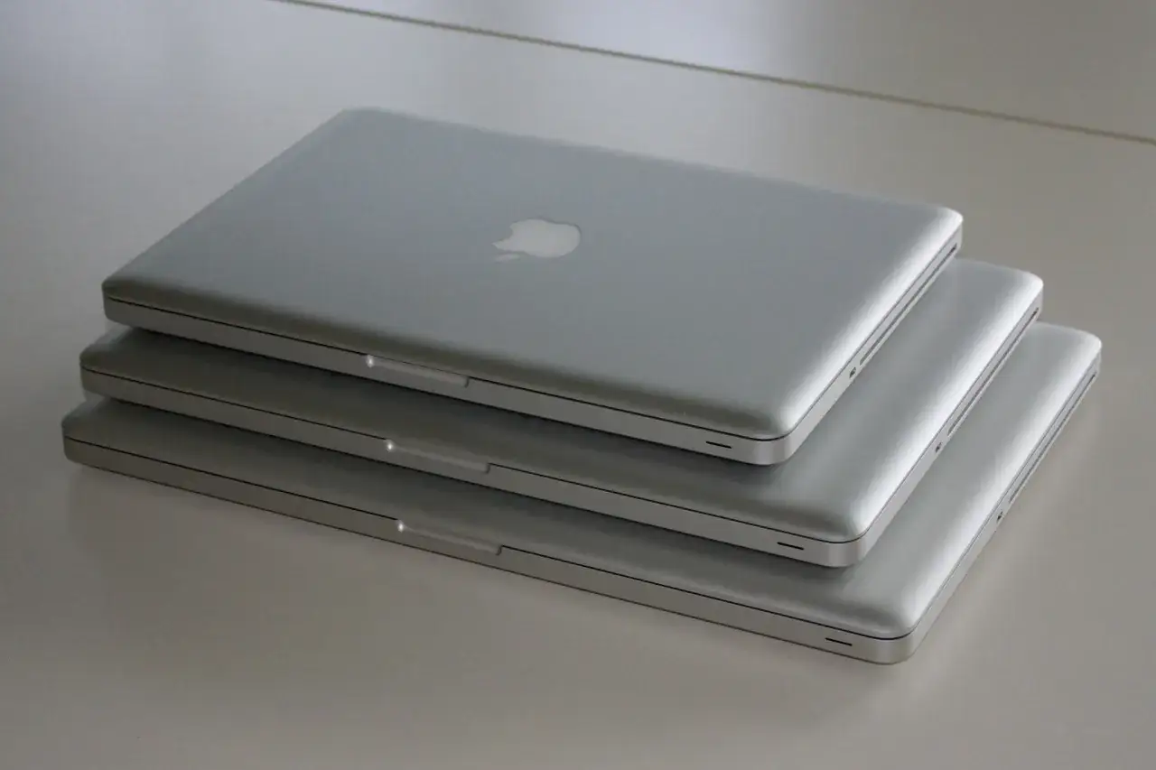 Stos trzech srebrnych laptopów. Chcesz wiedzieć, jak sprawdzić ile cali ma laptop?
