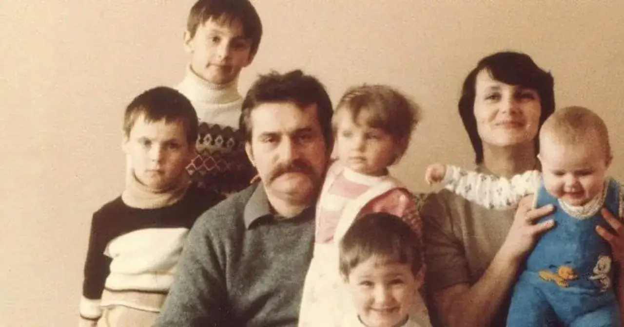 Lech Wałęsa z żoną i szóstką dzieci. Rodzina pozuje do wspólnego zdjęcia, widać radość na twarzach dzieci.