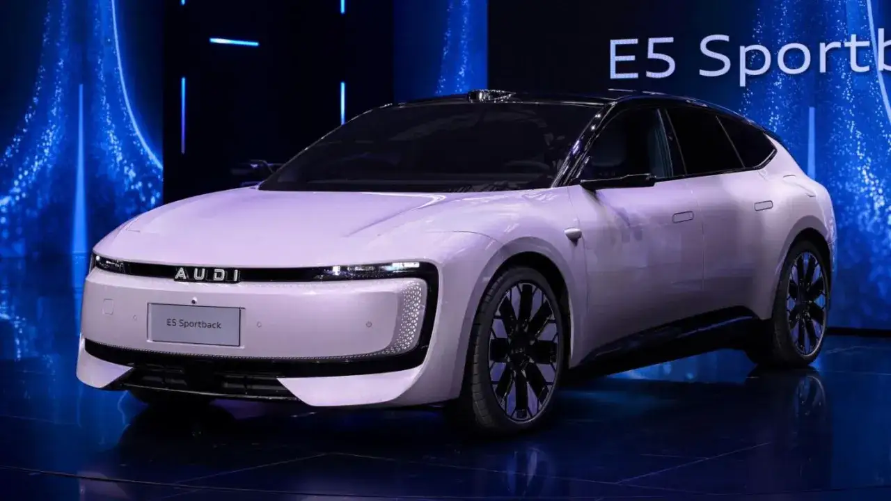 Le concept Audi E5 Sportback, une berline électrique futuriste, se dévoile sur scène.