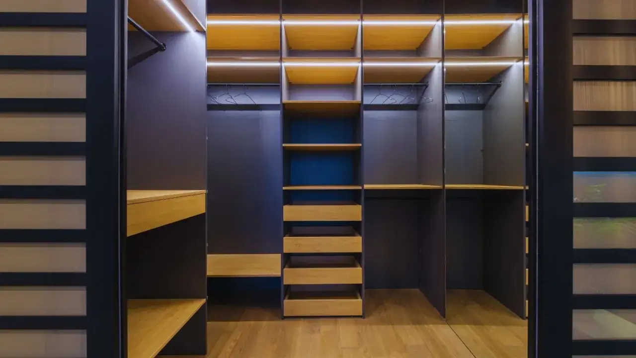 Armario moderno con estantes de madera y cajones, ideal para aprender como organizar un armario.