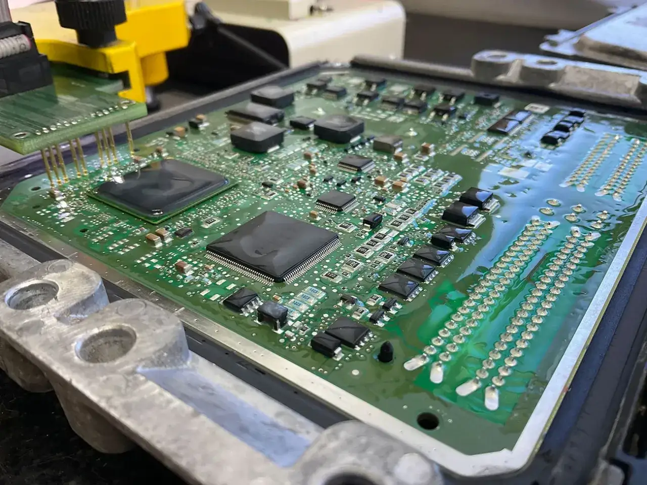 Placa de circuito de una unidad de control electr&oacute;nico (ECU) de Peugeot p0606, con chips y conectores.
