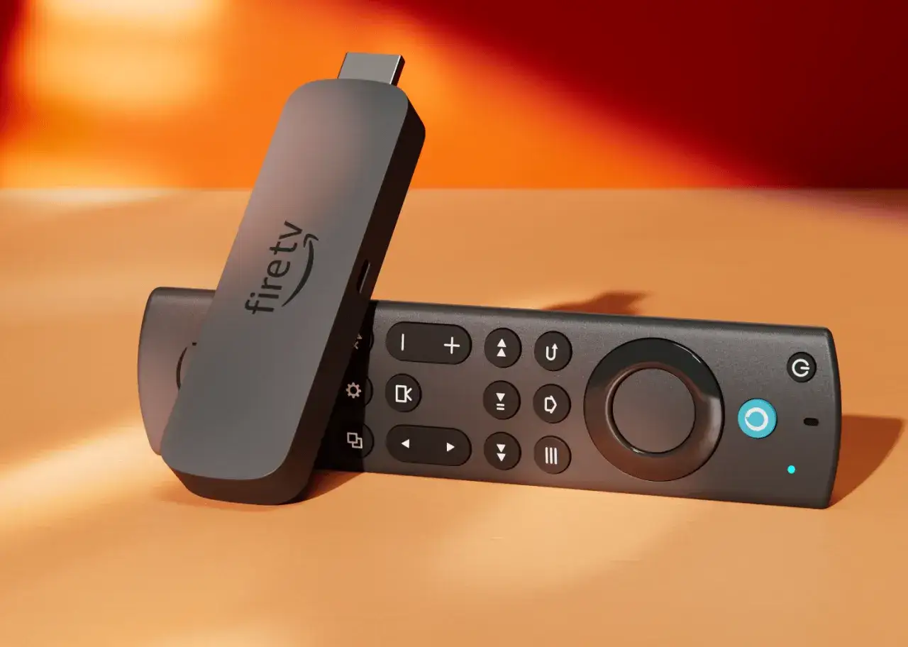 Ein Fire TV Stick und seine Fernbedienung liegen auf einem orangen Tisch. So einfach ist es, was ist Fire TV.