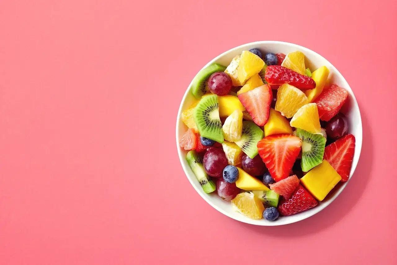 Kolorowa sałatka owocowa z truskawkami, kiwi, mango, pomarańczą i borówkami. Idealna na zdrową przekąskę, zawiera owoce o niskim indeksie glikemicznym.