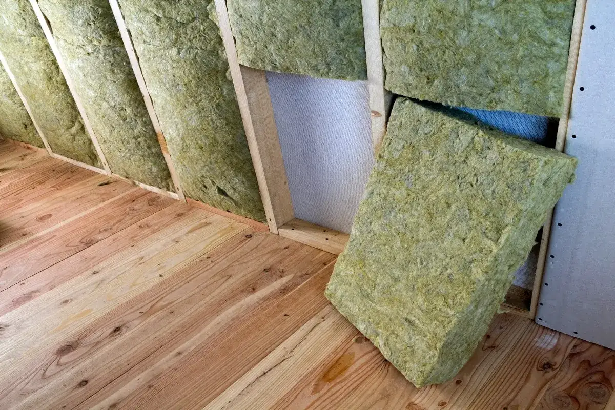 Isolation d'un grenier avec de la laine de verre sans pare-vapeur, pos&eacute;e sur un plancher en bois brut.