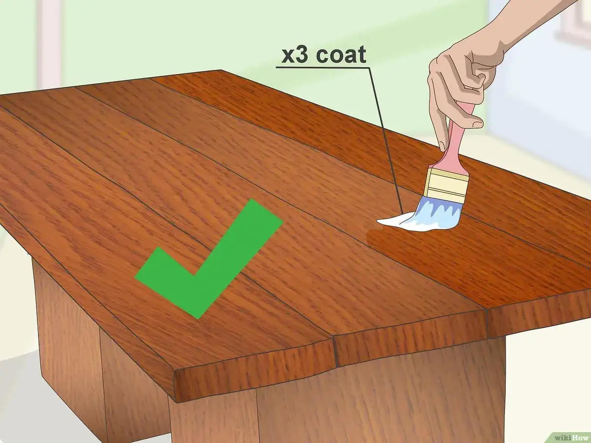 Come impermeabilizzare il legno: applicare tre mani di vernice protettiva con un pennello su un tavolo di legno.