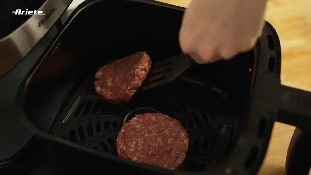 Due hamburger crudi pronti per essere cotti nella friggitrice ad aria.