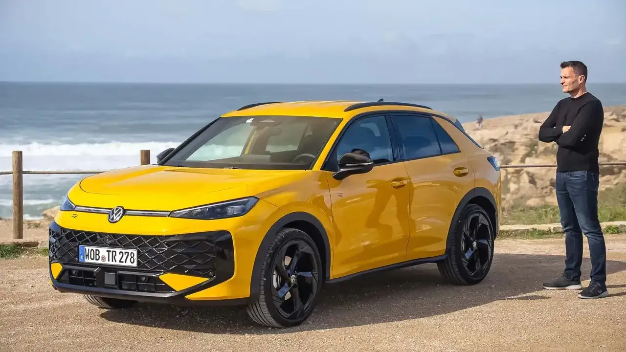 Gelber VW T-Roc am Meer. Ein Mann steht daneben. Keine Rede von vw t-roc kinderkrankheiten, nur ein schickes Auto.