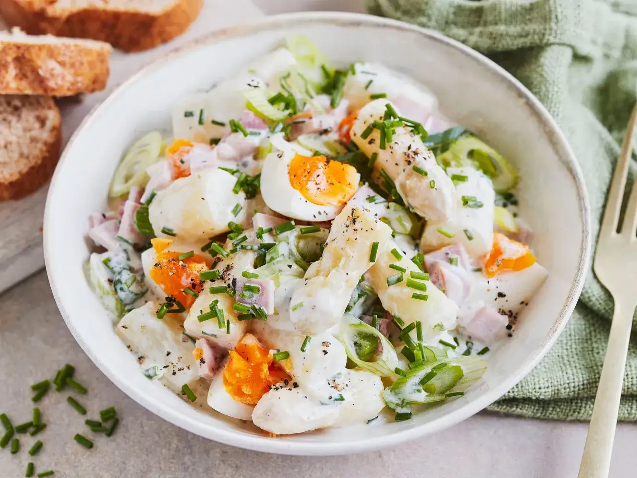 Ein cremiger Spargelsalat mit Kartoffeln, Ei und Schinken, garniert mit Schnittlauch. Perfekt als leichtes Mittagessen oder als Beilage. Ein tolles Spargelsalat Rezept!