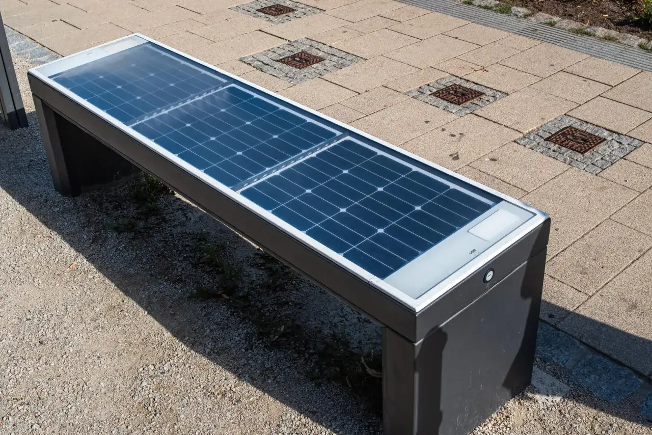 Nowoczesna ławka z panelami **solar edge** na siedzisku, idealna do ładowania urządzeń w plenerze.