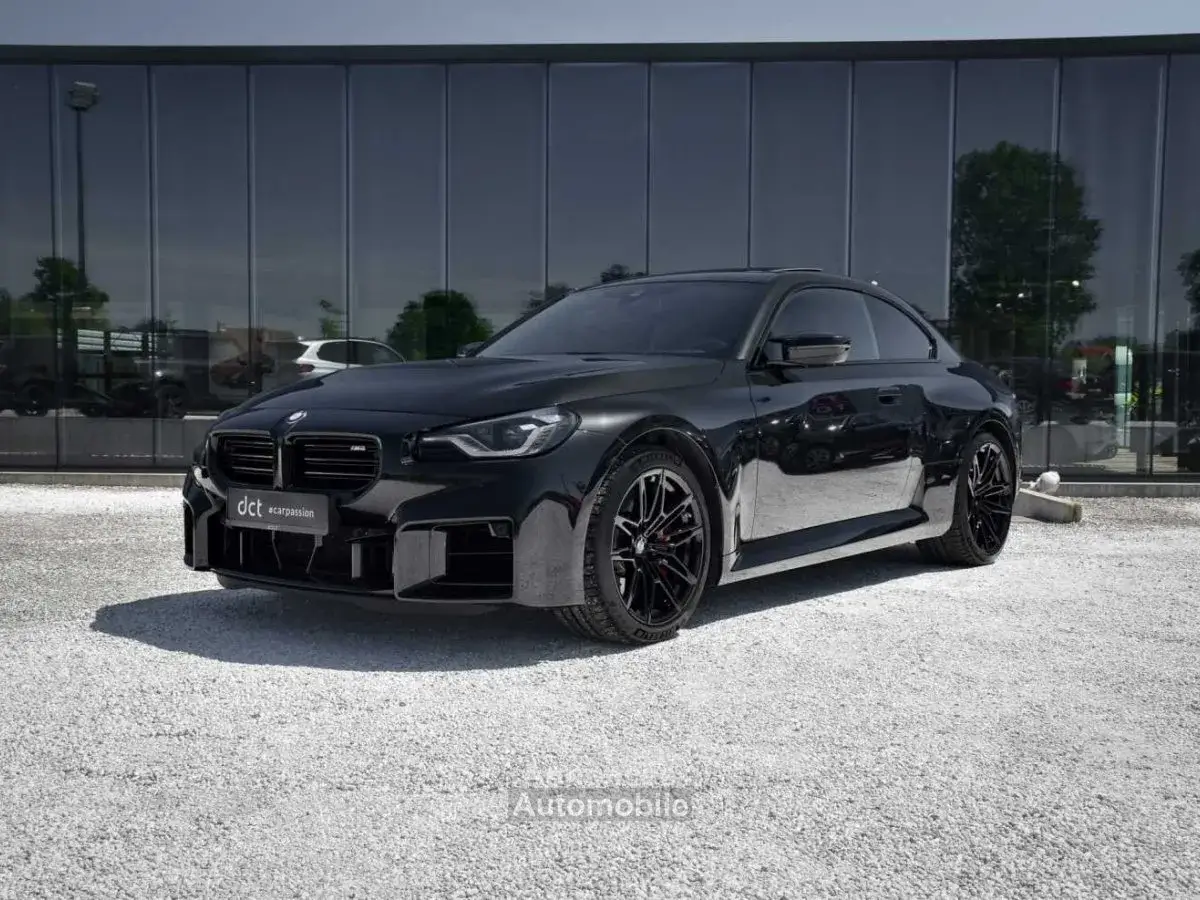 BMW M2 Competition noire, prête à libérer ses chevaux sous le soleil. Un design agressif et des performances de pointe.