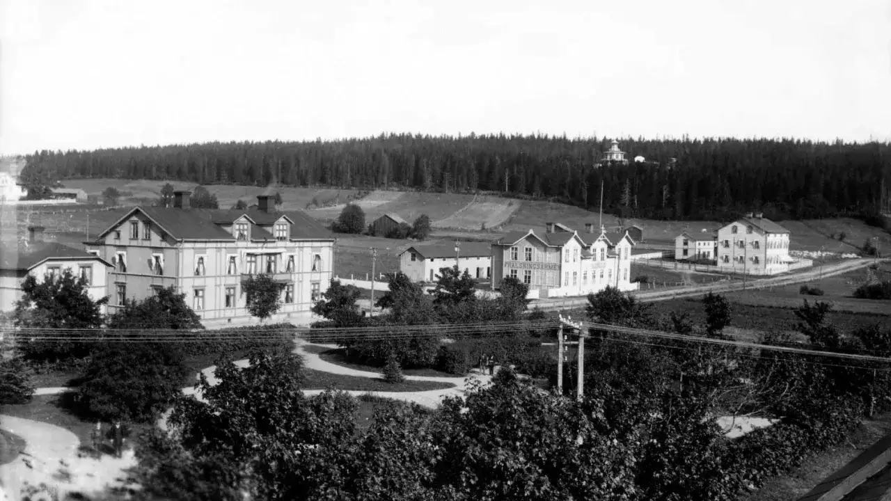 Vacker vy &ouml;ver ett svenskt samh&auml;lle, troligen fr&aring;n sverige 1960. Hus och skog dominerar landskapet.