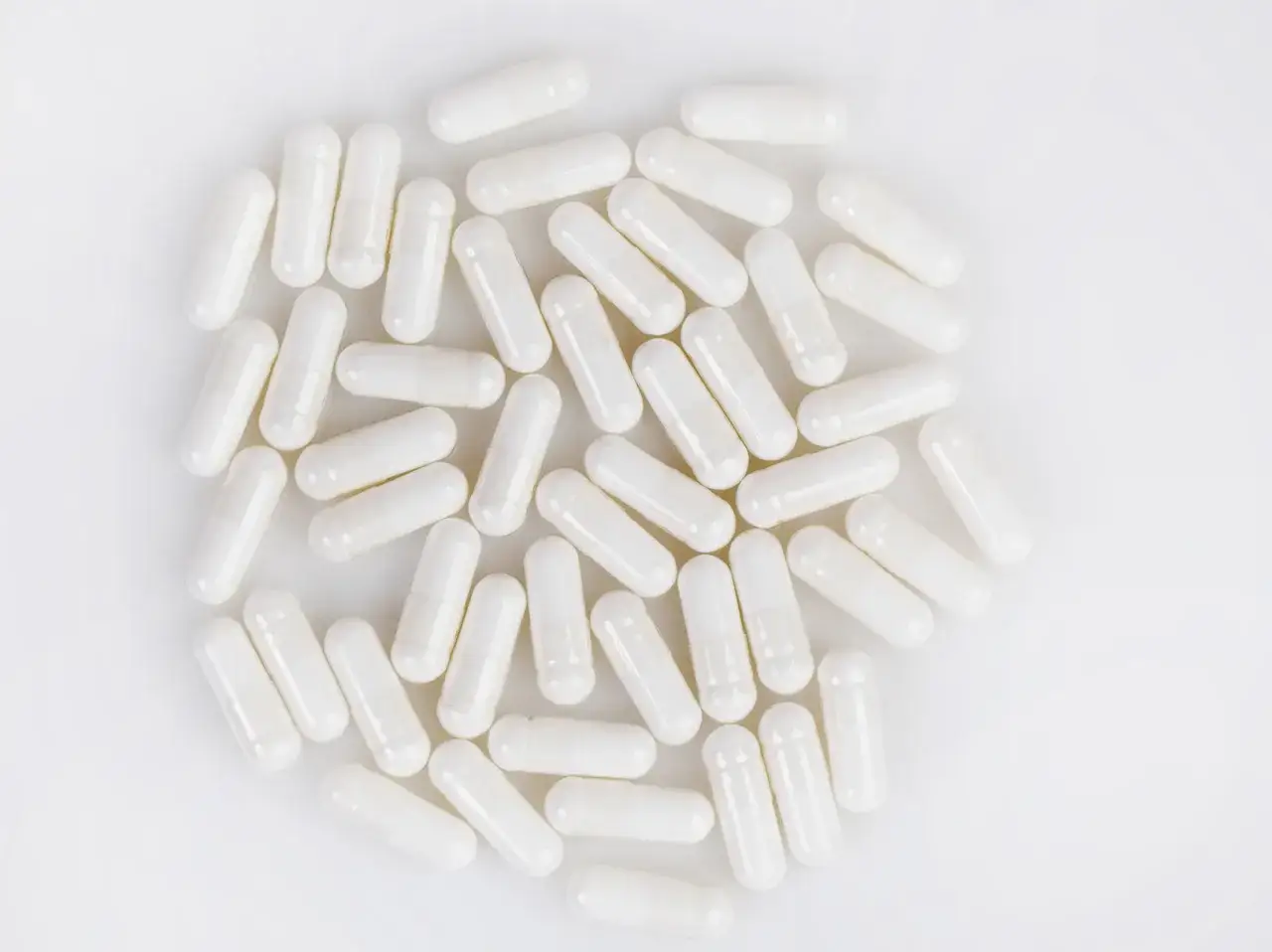 Haufen wei&szlig;er Kapseln, die ein NAC-Supplement darstellen.