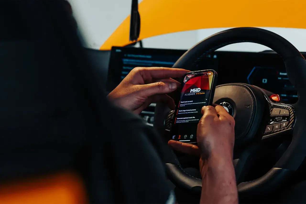 Manos ajustando el m&oacute;vil en un coche deportivo, listo para un 