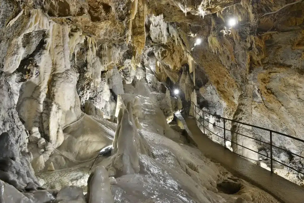 Sentiero illuminato tra le formazioni calcaree delle fabbriche di Vergemoli, un mondo sotterraneo di stalattiti e stalagmiti.